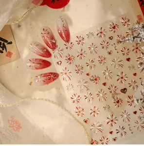 Detail of red and gold firework nail stickers with heart patterns and pearl 3D accents