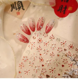 Detail of festive red gradient press-on nails with gold firework and heart stickers