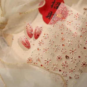 Detail view of New Year nail art stickers featuring red fireworks and heart designs