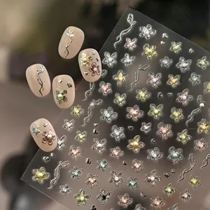 Exquisite floral nail art stickers with metallic accents and faux pearl details on soft pink nails