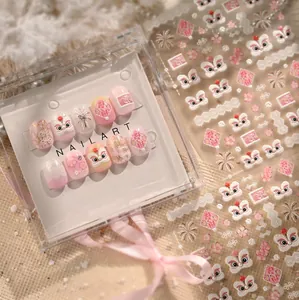 Detail view of pink lion dance press-on nails and festive fireworks stickers in a box