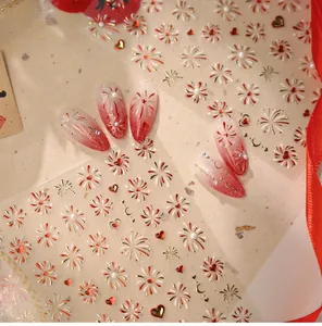 Detail of red firework and heart nail art stickers with gold foil accents on a beige card