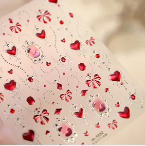 Macro-detail van M1332 nagelstickers met rode robijnrode harten, strikken en zilveren kralen