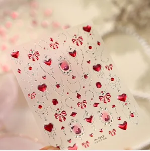 Detail van nagelstickers m-1332 met rode harten en zilveren strikken op roze achtergrond