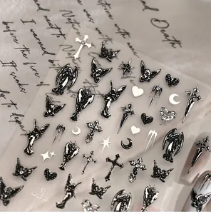 Makro-Detail von Gothic-Engel- und Kreuz-Nagelstickern mit metallischer Relieftestur