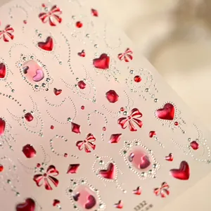 Nagelstickers met roze hartjes, edelstenen, rode strikjes en zilveren kralendetails