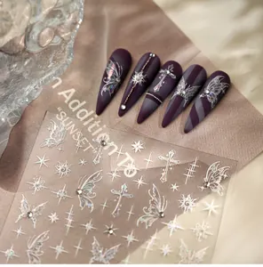 Detailed view of laser butterfly nail stickers with 3D crystal accents and cross patterns