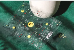 Detailed 5D embossed nail stickers featuring yellow smiles and stars on a white base