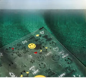 Close-up of 5D embossed nail stickers featuring yellow smiley faces and cute star patterns