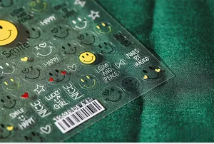 Macro shot of TS-039 5D nail art stickers with yellow smiley faces and hearts on green fabric