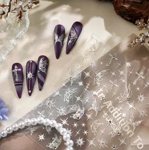 Detail of silver laser butterfly and cross nail stickers on purple matte nails with pearls