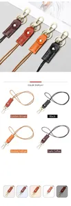 Detail of leather keychains in brown and black with gold metal hooks and color options
