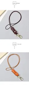 Detail of dark brown and sunset yellow leather keychains with golden metal hardware