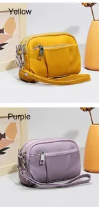 Dettaglio di mini borse in pelle gialla e viola con design a tre cerniere lampo