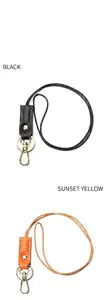 Detail view of leather keychains in black and sunset yellow with metallic lobster clasps