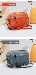 Dettaglio dei mini portafogli in pelle con zip multiple in colori arancione e blu denim