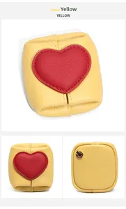 Detail of yellow pebbled leather mini pouch with red heart patch and metal ring