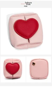 Macro shot of cherry blossom pink litchi leather coin purse with red heart detail