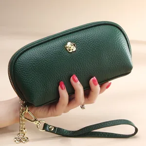 Dark green pebbled leather long clutch bag with golden flower logo and clover charm strap