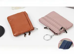 Détail de mini portefeuilles en cuir véritable avec texture grainée et fermetures éclair