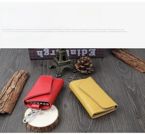 Detailed view of red and yellow leather key pouches with metal hooks on vintage wood
