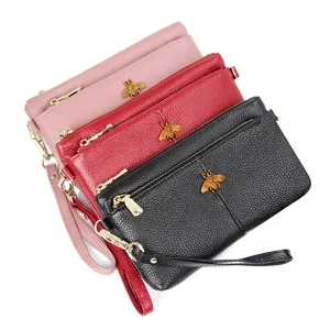 Vintage leather clutch wallets in pink, red and black with golden bee logo detail