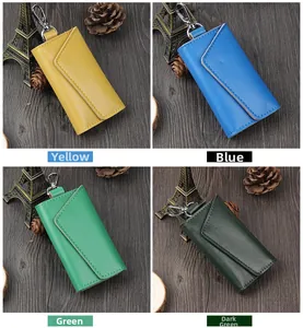 Detail view of leather key cases in four colors with metal swivel hooks on wood background