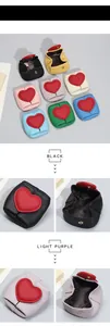 Detailed view of the heart-shaped flap and metal snap button on mini leather coin pouches