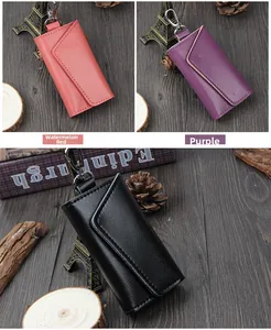 Detailed view of leather key cases in watermelon red, purple and black with metal hooks