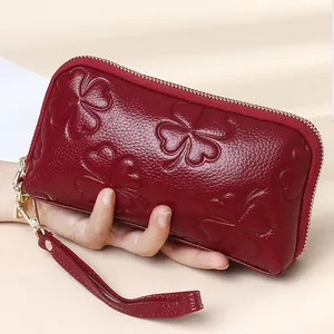 Burgundy clover embossed leather shell clutch bag with gold zipper and wrist strap