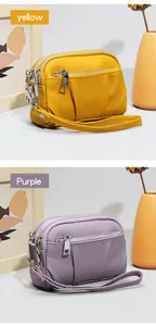 Detail view of mini genuine leather purses with three-layer zippers in yellow and purple