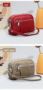 Close-up of red and light gray pebble leather mini purses with triple silver zippers
