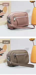 Detail of pink and khaki leather coin purses with three zippers and lychee texture