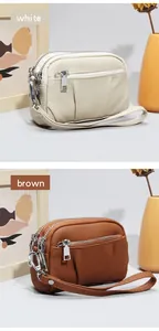 Detailed view of genuine leather mini coin purse with three zippers and wrist strap