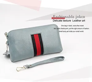 Macro detail of blue pebble grain leather wallet featuring red and black stripe accents