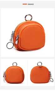 Detailopname van de oranje lederen mini-portemonnee met dubbele rits en metalen sleutelring