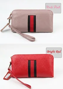 Detail view of red and nude pink leather wallets with signature striped webbing trim