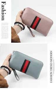 Detail of genuine leather zip wallet featuring pebbled texture and striped webbing