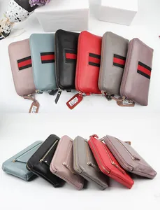 Detailed view of top-grain leather long wallets with striped webbing in multiple colors