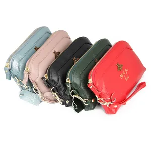 Litchi texture leather clutch bag for women featuring golden bee accent and wrist strap