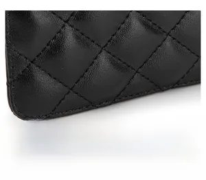 Macro shot of quilted sheepskin leather texture and fine stitching on the black coin purse