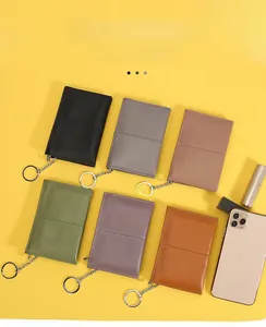 Top grain leather coin purses in multiple colors with key rings on a yellow background