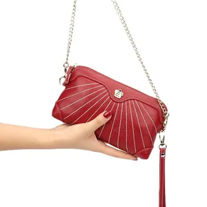 Red lychee pattern leather clutch bag with white radial stitching and chain strap