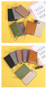 Compact leather coin pouch with zipper and keychain ring shown against phone for size