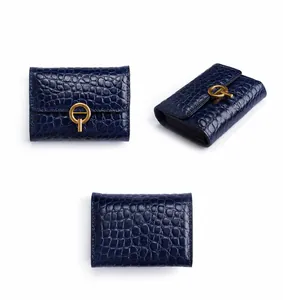 Vista triple del tarjetero de cuero azul real con relieve de cocodrilo y hebilla dorada