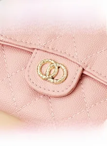 Close-up of pink quilted leather wallet with gold ring hardware and litchi grain texture