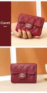 Detail of claret quilted leather wallet featuring a gold ring logo and flip cover