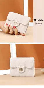 Close-up of quilted off-white leather wallet with gold emblem and textured finish