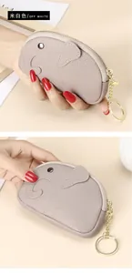 Miniature leather elephant coin purse in off-white finish held in hand for size detail