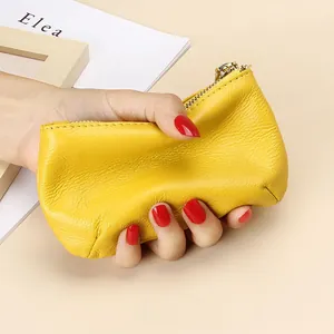 Monedero pequeño de cuero suave amarillo con cremallera y textura de piel natural